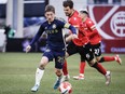 Vancouver Whitecaps FC midfielder Ryan Gauld, left, controls the ball as Cavalry FC midfielder Charlie Trafford chases him during second half soccer action in the Canadian Championship quarterfinal, leg 1, in Calgary, Tuesday, May 7, 2024.