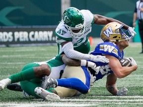 Winnipeg Blue Bombers receiver Drew Wolitarsky (82) is tackled by Saskatchewan Roughriders defenders during the first half of preseason CFL football action in Regina, Monday, May 20, 2024.