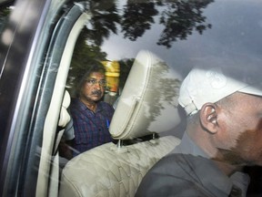 FILE- Arvind Kejriwal, leader of the Aam Admi Party, or Common Man's Party, left, leaves in a car after a court extended his custody for four more days, in New Delhi, India, March 28, 2024. India's top court on Friday gave interim bail to the top opposition leader who was arrested nearly seven weeks ago.