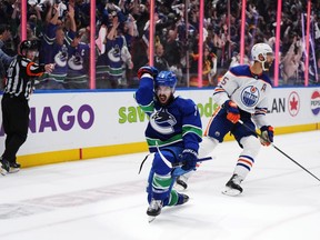 Vancouver Canucks' Conor Garland, left, celebrates his goal as Edmonton Oilers' Darnell Nurse reacts during the third period in Game 1 of an NHL hockey Stanley Cup second-round playoff series, in Vancouver, on Wednesday, May 8, 2024.