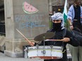 A pro-Palestinian protester drums at the Roddick Gates of McGill University in Montreal Sunday, April 28, 2023. This was very near an encampment on the grounds of McGill campus in Montreal to protest the war in Gaza.
