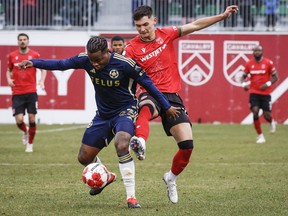 Vancouver Whitecaps FC defender Javain Brown (left) controls the ball as Cavalry FC attacker Lleyton Brooks checks during first half soccer action in the Canadian Championship quarterfinal, leg 1, in Calgary, Tuesday, May 7, 2024.