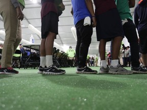FILE - In this July 9, 2019, file photo, immigrants line up in the dinning hall at the U.S. government's newest holding center for migrant children in Carrizo Springs, Texas. The Biden administration plans to partially end the 27-year-old court supervision of how the federal government cares for child migrants, shortly after producing its own list of safeguards against mistreatment.