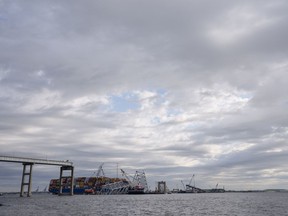 The collapsed Francis Scott Key Bridge lays on top of the container ship Dali, Thursday, April 25, 2024, in Baltimore.