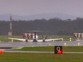 In this image taken from video, a light plane with three people aboard lands safely without landing gear at Newcastle Airport, Australia, Monday, May 13, 2024, after circling the airport for almost three hours to burn off fuel. The twin-turboprop Beechcraft Super King Air had just taken off from the airport north of Sydney for a 180-kilometer (112-mile) flight north to Port Macquarie when the pilot raised the alarm saying the landing gear had failed. (Australian Broadcasting Corporation via AP)