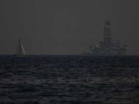 FILE - An offshore drilling rig is seen in the waters off Cyprus' coastal city of Limassol, on July 5, 2020 as a sailboat sails in the foreground. The Cyprus government has given U.S. energy company Chevron another six months to come up with a revised plan to develop a sizeable natural gas deposit off the island nation's southern coastline after an earlier plan was deemed to lack a specific timetable, an official said Thursday, May 2, 2024.