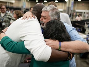 FILE - David Meredith, middle, hugs fellow observers after an approval vote at the United Methodist Church General Conference Wednesday, May 1, 2024, in Charlotte, N.C. When the United Methodist Church removed anti-LGBTQ language from its official rules in recent days, it marked the end of a half-century of debates over LGBTQ inclusion in mainline Protestant denominations. The moves sparked joy from progressive delegates, but the UMC faces many of the same challenges as Lutheran, Presbyterian and Episcopal denominations that took similar routes, from schisms to friction with international churches to the long-term aging and shrinking of their memberships.