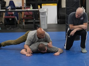 Instructor Dave Rose, right, watches as fellow instructor Enrico Solomon, top, demonstrates the basics of ground control on a student during an Arrest & Control Instructor course in Sacramento, Calif., on Thursday, Jan.18, 2024. Law enforcement officers from various agencies attend the class where they receive instruction on basic techniques of arrest and control that they to take back to their agencies to pass along to fellow officers.