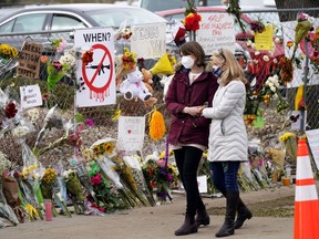 FILE - Mourners walk along the temporary fence put up around the parking lot of a King Soopers grocery store where a mass shooting took place earlier in the week, Thursday, March 25, 2021, in Boulder, Colo. State experts have found the man charged with shooting and killing 10 people at a Colorado supermarket in 2021 had untreated mental illness but was legally sane at the time of the attack, lawyers said Tuesday, May 7, 2024.