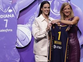 CORRECTS TO CAITLIN CLARK NOT CAITLYN CLARK - Iowa's Caitlin Clark, left, poses for a photo with WNBA commissioner Cathy Engelbert, right, after being selected first overall by the Indiana Fever during the first round of the WNBA basketball draft, Monday, April 15, 2024, in New York.