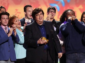 FILE - Dan Schneider, center, accepts an award in Los Angeles. Schneider sued the makers of "Quiet on Set: The Dark Side of Kids TV" on Wednesday, May 1, 2024, alleging the makers of the documentary series wrongly implied that he sexually abused the child actors he worked with.