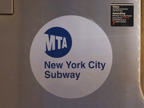 FILE - The MTA logo is seen on the side of a New York City subway car, April 23, 2020, in the Queens borough of New York. A man set a cup of liquid on fire and tossed it at fellow subway rider in New York City, setting the victim's shirt ablaze and injuring him. The random attack happened on a No. 1 train in lower Manhattan on Saturday afternoon, May 25, 2024, city police said, adding that the suspect was in custody.