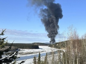 FILE - Smoke rises after a Douglas C-54 Skymaster plane crashed into the Tanana River outside Fairbanks, Alaska, Tuesday, April 23, 2024. A witness who saw the vintage military plane loaded with fuel for delivery shortly after it took off from an airport in Fairbanks, last week said the far-left engine of the aircraft was not running but trailing a small, white plume of smoke, according to a preliminary crash report released Thursday, May 2.