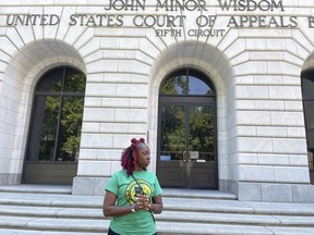 FILE - Teliah Perkins stands in front of the federal appeals court building in New Orleans, May 3, 2023, following a hearing on her lawsuit against two St. Tammany Parish, La., sheriff's deputies stemming from her arrest in May 2020. A teenager who video-recorded his mother Teliah's forceful arrest by Louisiana sheriff's deputies has been awarded $185,000 by a federal jury in a lawsuit filed over one deputy's attempt to interfere with the recording.