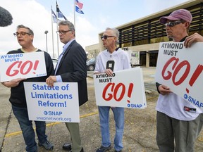 FILE - Members of SNAP, the Survivors Network of those Abused by Priests, including, from left, Kevin Bourgeois, John Gianoli, Richard Windmann and John Anderson, hold signs during a conference in front of the New Orleans Saints training facility, Jan. 29, 2020, in Metairie, La. Louisiana's Supreme Court agreed Friday, May 10, 2024, to reconsider its recent ruling that wiped out a state law giving adult victims of childhood sexual abuse a renewed opportunity to file damage lawsuits.