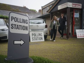 Voters leave a polling station at St Alban's Church, south London, after casting their votes in the local and London Mayoral election Thursday, May 2, 2024.