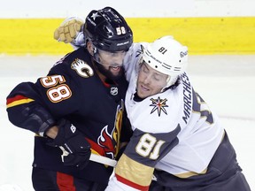 Vegas Golden Knights' Jonathan Marchessault, right, and Calgary Flames' Oliver Kylington jostle for position during second-period NHL hockey action in Calgary, Thursday, March 14, 2024. Kylington, Carolina Hurricanes goaltender Frederik Andersen and Arizona Coyotes goaltender Connor Ingram are the finalists for this season's Bill Masterton Memorial Trophy.