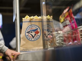 With foot-long hotdogs roughly $13 and 515-mL premium draft beers nearing $15, it can be expensive to dine at the Rogers Centre, but many Canadians have found ways to save on food at the Toronto venue, including sharing popcorn amongst friends or attending on days when hot dogs are sold for a loonie. Fans line up for food during the Toronto Blue Jays home opener on Friday, April 8, 2022.