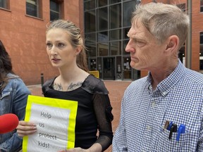 Amanda Householder, center, speaks outside the St. Louis office of Missouri Attorney General Andrew Bailey on Monday, May 13, 2024, as David Clohessy, right, listens. They were among a group of people urging Bailey to take action in response to allegations of child abuse at Christian boarding schools in southern Missouri.