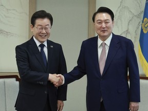 South Korean President Yoon Suk Yeol, right, shakes hands with main opposition Democratic Party leader Lee Jae-myung during a meeting at the presidential office in Seoul South Korea, Monday, April 29, 2024.