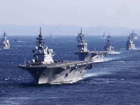 FILE - Japan's Maritime Self-Defense Force helicopter carrier JS Izumo, foreground, and other warships join an international fleet review in Sagami Bay, south of Tokyo, on Nov. 6, 2022. Japan's defense chief has called for the bolstering of its anti-drone capability after a drone footage posted on a Chinese social media site showed a Japanese aircraft carrier docked at a restricted navy port west of Tokyo. (Kyodo News via AP, File)