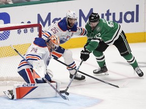 Edmonton Oilers goaltender Stuart Skinner (74) blocks a shot by Dallas Stars right wing Evgenii Dadonov (63) with help from teammate Darnell Nurse (25) during the third period in Game 2 of the Western Conference finals in the NHL hockey Stanley Cup playoffs Saturday, May 25, 2024, in Dallas.