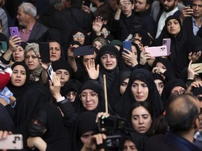 In this photo released by the Iranian Presidency Office, people mourn in a funeral ceremony of President Ebrahim Raisi and his companions who were killed in a helicopter crash on Sunday in a mountainous region of the country's northwest, in the city of Tabriz, Iran, Tuesday, May 21, 2024. (Iranian Presidency Office via AP)