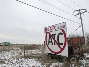 FILE - A grain wagon supports a sign against the proposed transmission line by American Transmission Company, ITC Midwest and Dairyland Power Cooperative, along Highway 18-151 near Ridgeway, Wis., Dec. 8, 2018. Utilities looking to finish building a high-voltage power line linking Iowa and Wisconsin completed a contentious land deal Thursday that allows them to build on a Mississippi River federal wildlife refuge.
