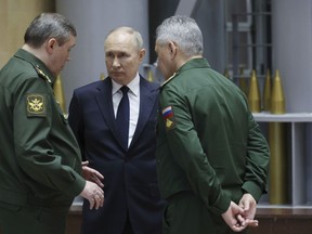 FILE - Russian President Vladimir Putin, center, talks with Russian Chief of General Staff Gen. Valery Gerasimov, left, and Russian Defense Minister Sergei Shoigu after a meeting with military leaders in Moscow, Russia, on Dec. 19, 2023. The Kremlin says Russia's President Vladimir Putin has signed a decree appointing Sergei Shoigu as secretary of Russia's national security council, replacing Nikolai Patrushev. The appointment Sunday comes after Putin proposed to appoint Andrei Belousov as the country's defense minister instead of Shoigu, who has served in the post for years.