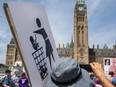 A pro-life protester holds a sign on Parliament Hill ahead of the National March for Life in Ottawa, Ontario, on May 12, 2022.