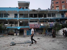 Palestinians walk past a UN school in Gaza