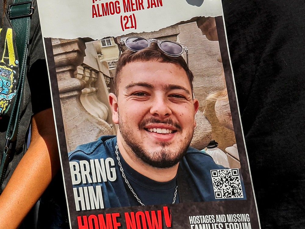 Friends of Almog Meir Jan, one of the four Israeli hostages that were rescued from Hamas, hold a poster with his image as they gather outside Sheba Tel-HaShomer Medical Centre after the hostages were transferred there, in Ramat Gan on June 8, 2024.