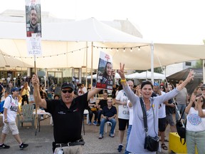 People celebrate as they hold photos of released hostages
