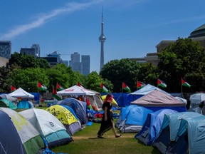 A woman walks between the tents in the pro-Palestinian encampment set up at the University of Toronto campus, in Toronto, Sunday, May 26, 2024.