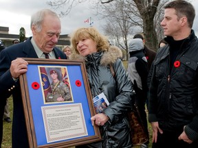 Three people looking at a plaque.