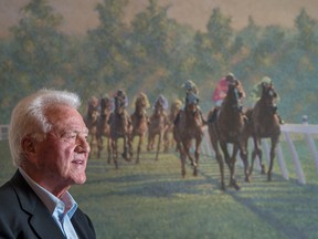 Frank Stronach and a painting of racehorses.