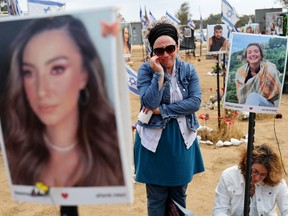 People mourn surrounded by photos of Hamas victims.