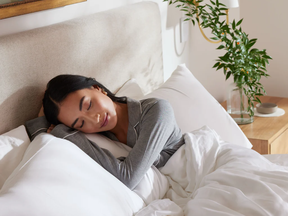 cozy earth discount code: woman sleeps in bed wearing cozy earth pajamas