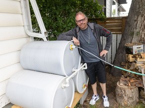 Ron Leitch shows off his water barrel set up behind his home in Calgary on Sunday, June 16, 2024.