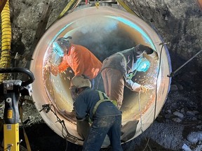 Welders at work on the broken water main in Montgomery, in northwest Calgary.