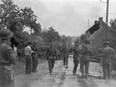 Maj. David V. Currie, left, with pistol in hand, of the South Alberta Regiment, accepts the surrender of German troops at Saint-Lambert-sur-Dive, France, on Aug. 19, 1944.