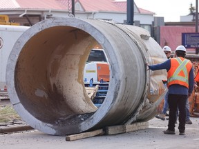 City of Calgary workers inspect the damaged water main pipe