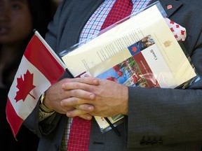 A new citizen holds an Canadian flag.