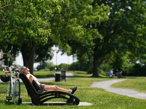A woman soaks in the sun in the Montreal borough of LaSalle on Tuesday, June 18, 2024. The heat wave that gripped Eastern Canada last week brought stifling conditions, put pressure on the electricity grid and broke several temperature records as residents sweltered.