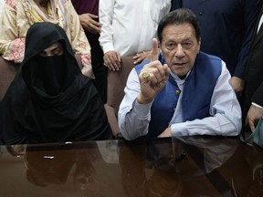 FILE - Pakistan's former Prime Minister Imran Khan, right, and Bushra Bibi, his wife, speak to the media before signing documents to submit surety bond over his bails in different cases, at an office of Lahore High Court in Lahore, Pakistan, on July 17, 2023. An appeals court in Pakistan Thursday, June 27, 2024 upheld the conviction and seven-year prison sentence of former Prime Minister Imran Khan and his wife for their 2018 marriage which was found to be unlawful, officials said.