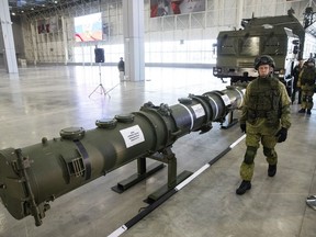 FILE - A Russian military officer walks past the 9M729 land-based cruise missile on display in Kubinka outside Moscow, Russia, on Jan. 23, 2019. Russian President Vladimir Putin has called for resuming production of intermediate-range missiles that were banned under a now-scrapped treaty with the US. The Intermediate-Range Nuclear Forces treaty, which banned ground-based missiles with a range of 500-5,500 kilometers (310-3,410 miles) was regarded as an arms control landmark when Soviet leader Mikhail Gorbachev and U.S. President Ronald Reagan signed it in 1988.