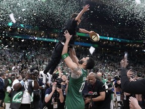 Boston Celtics forward Jayson Tatum (0) lifts his son Deuce as he celebrates with the team after the Celtics won the NBA basketball championship with a Game 5 victory over Dallas Mavericks, Monday, June 17, 2024, in Boston.
