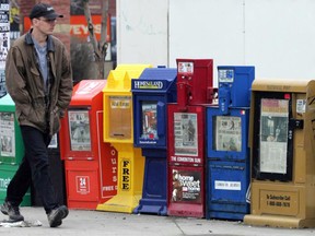 Newspaper boxes on a sidewalk.