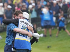Scotland's Robert MacIntyre celebrates with his father, Dougie MacIntyre, after winning the Canadian Open golf tournament in Hamilton on Sunday June 2, 2024.