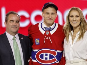 Ivan Demidov, centre, poses, after being selected by the Montreal Canadiens during the first round of the NHL hockey draft Friday, June 28, 2024, in Las Vegas. The announcement was made by singer Celine Dion, right.